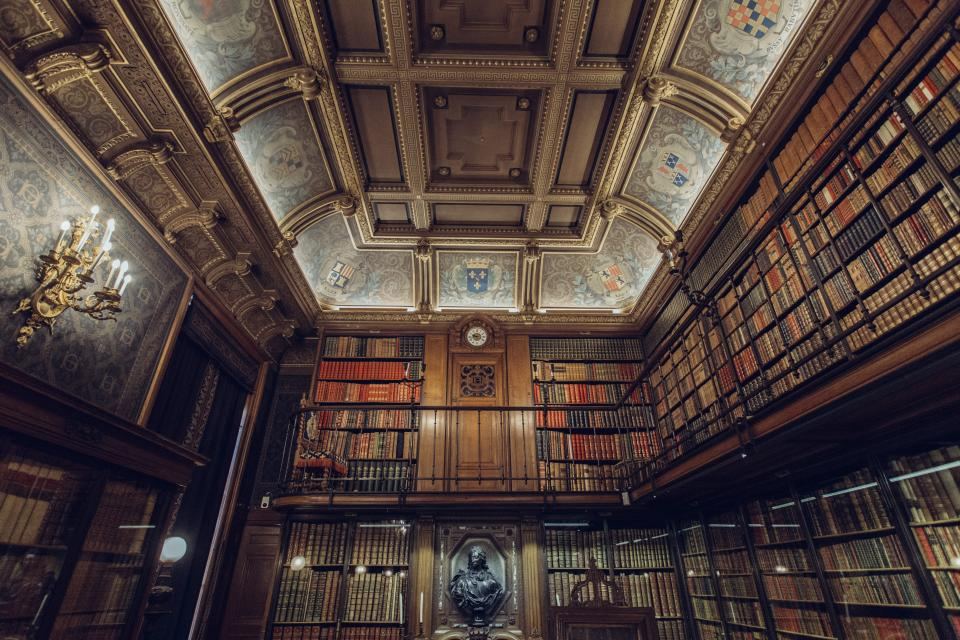 A historic reading room with ornate ceiling and shelves of law books
